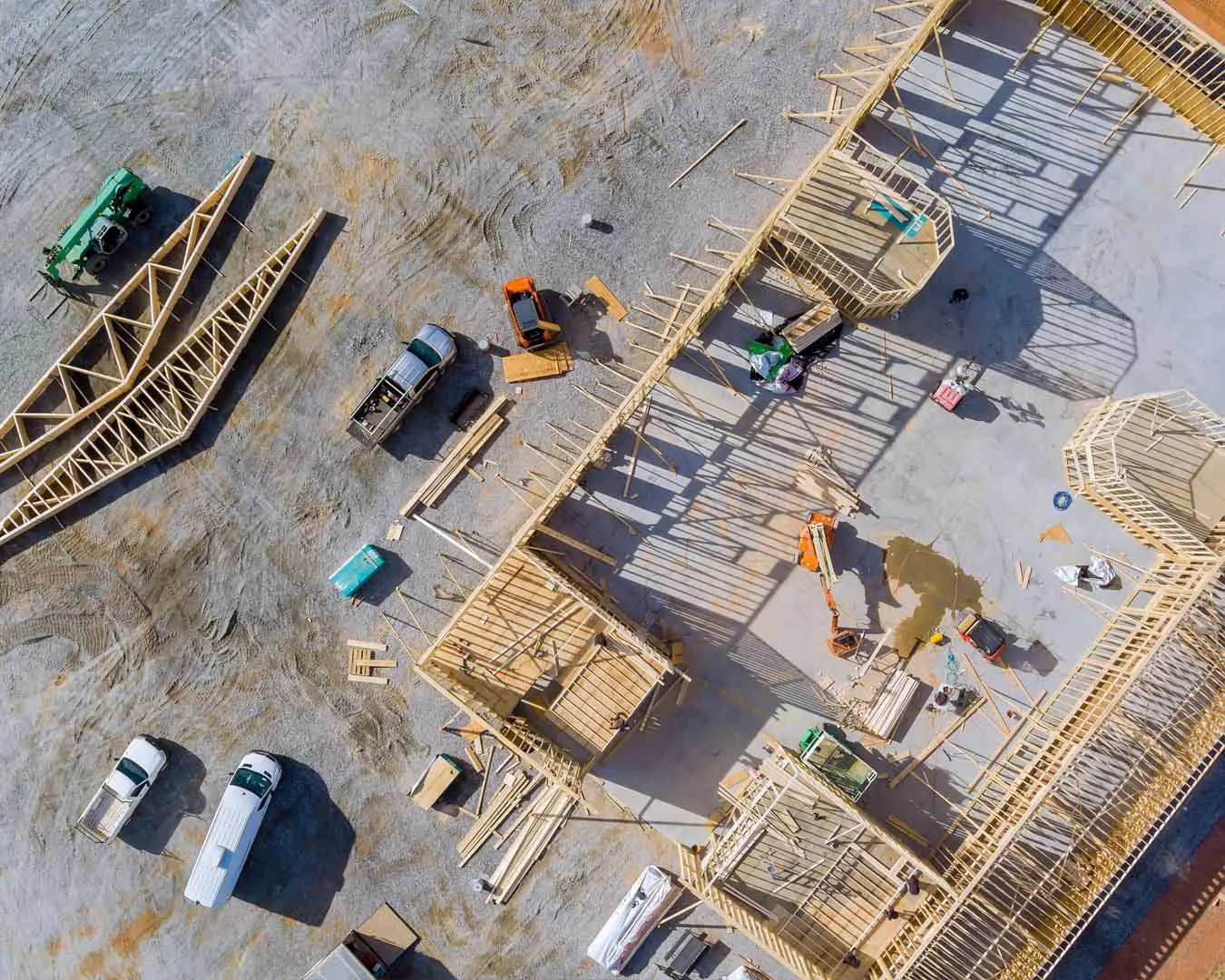 Aerial view of a commercial building under construction with the slab poured and wall framing underway