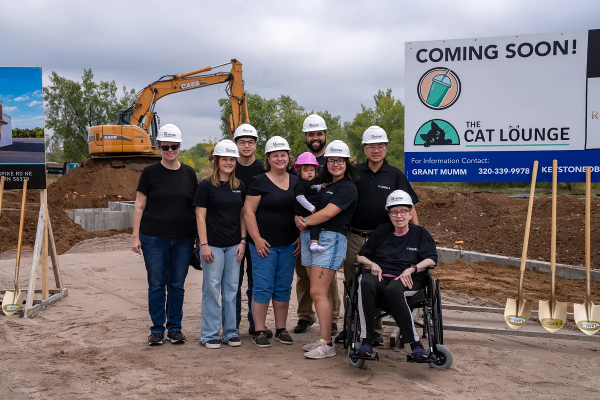 Core 4 groundbreaking group at the project sign in Sauk Rapids