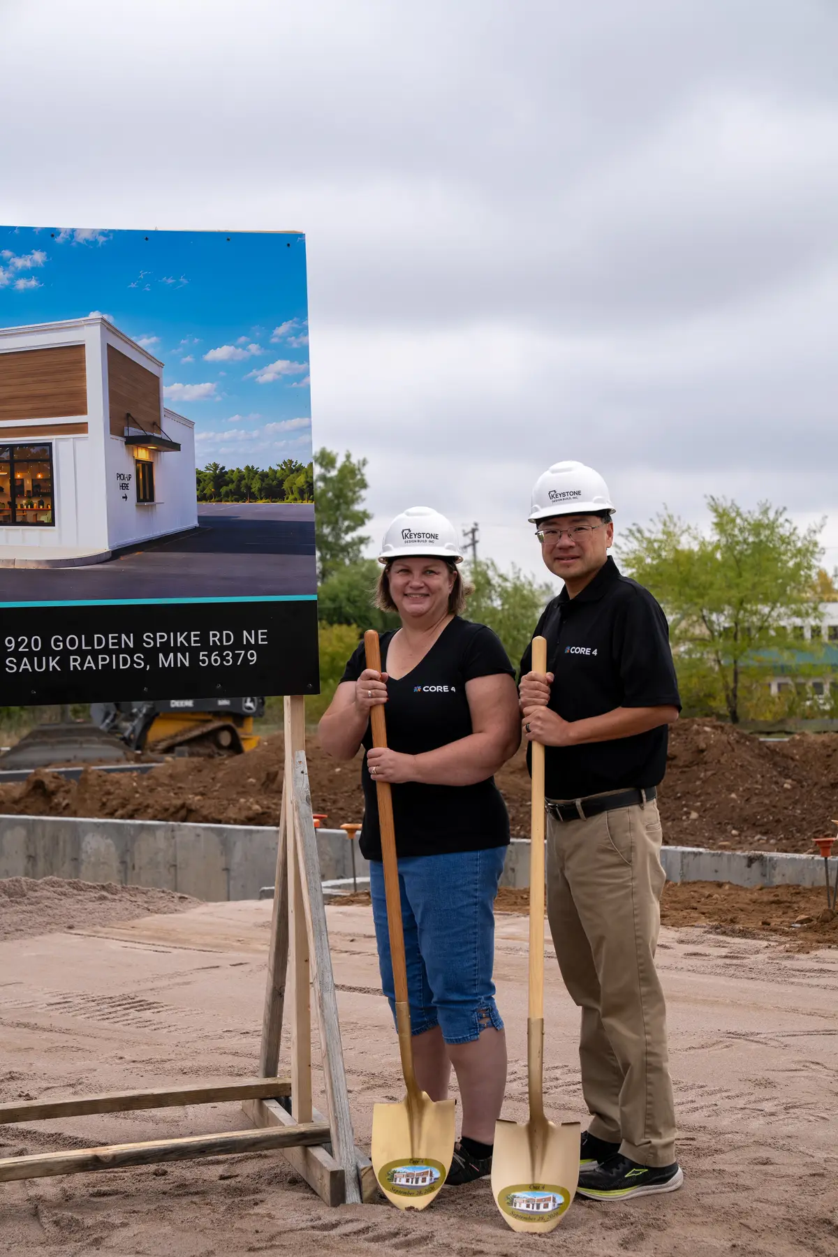 Guests beside the Core 4 sign at 920 Golden Spike Rd NE